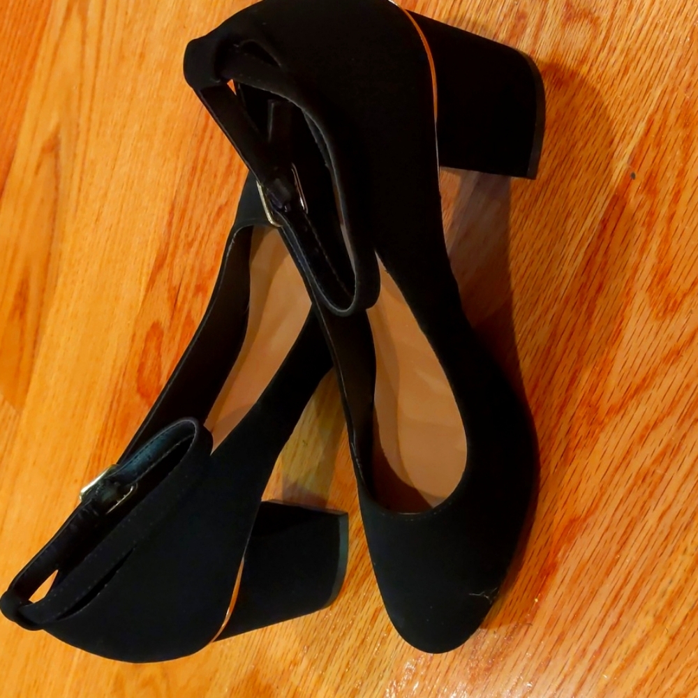 Black dress shoes with gold trim.